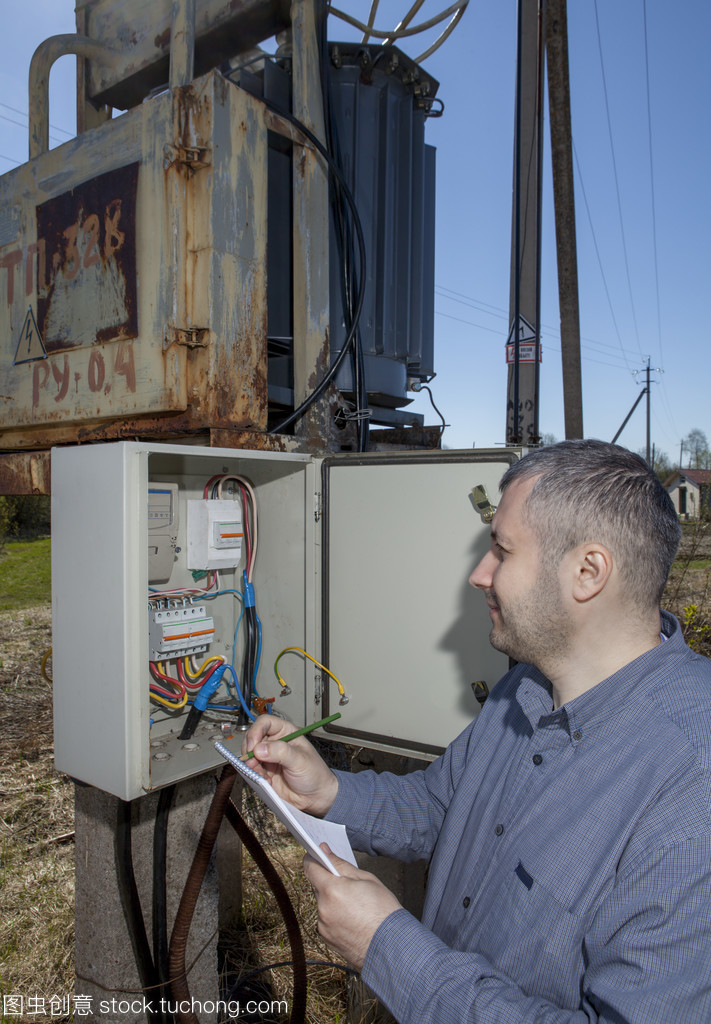 農(nóng)村變電站,農(nóng)夫檢查電力計數(shù)器檢查消費